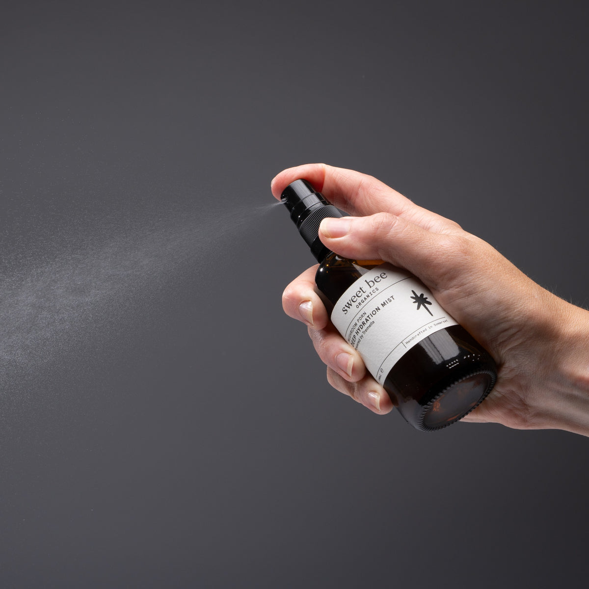 A hand spraying Deep Hydration Mist, showing the fine, even mist